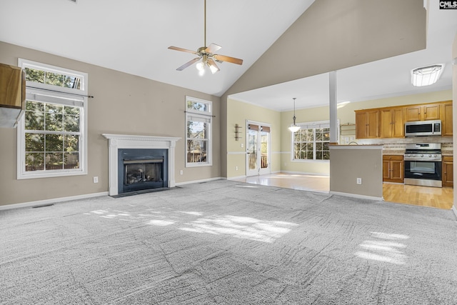 unfurnished living room featuring light carpet, ceiling fan, and high vaulted ceiling