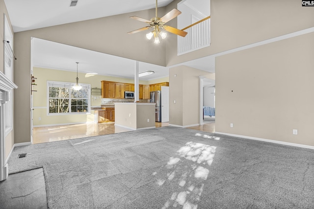 unfurnished living room with high vaulted ceiling, light carpet, and ceiling fan