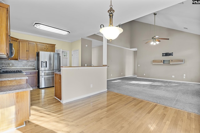 kitchen featuring appliances with stainless steel finishes, light carpet, tasteful backsplash, hanging light fixtures, and ceiling fan