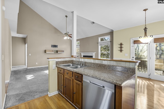 kitchen with vaulted ceiling, dishwasher, plenty of natural light, and sink