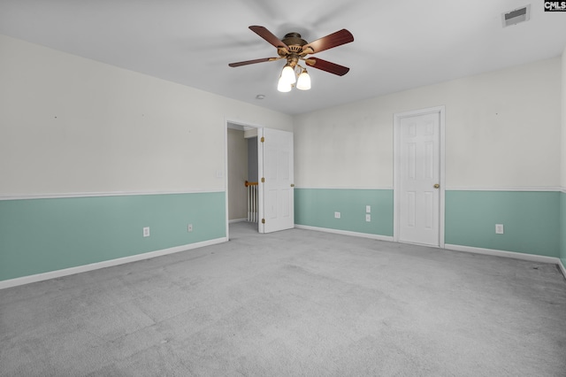 empty room with ceiling fan and light carpet