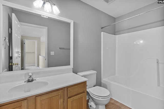 full bathroom featuring wood-type flooring, bathtub / shower combination, toilet, and vanity