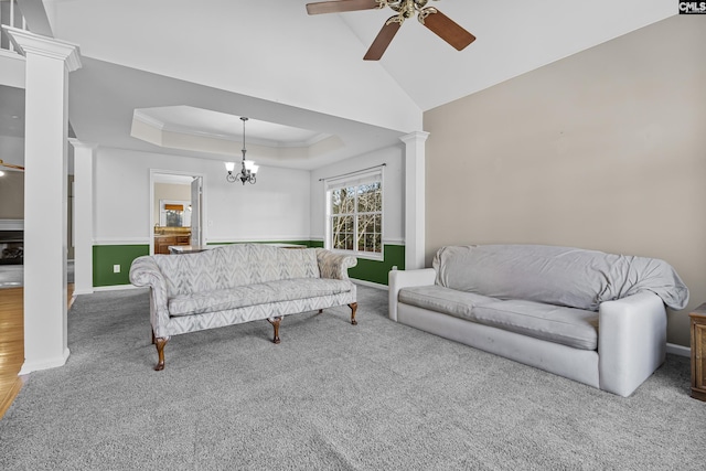 carpeted living room featuring ornate columns, ceiling fan with notable chandelier, and a raised ceiling