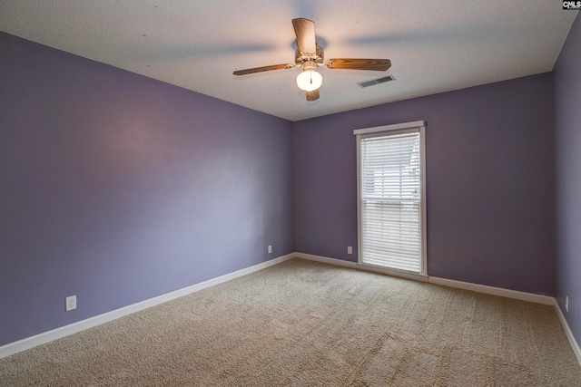 unfurnished room with carpet, visible vents, ceiling fan, a textured ceiling, and baseboards