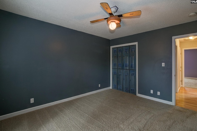 unfurnished bedroom featuring a closet, a textured ceiling, baseboards, and carpet flooring