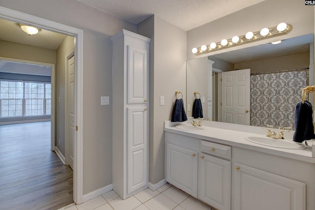 bathroom featuring a textured ceiling, tile patterned floors, and vanity