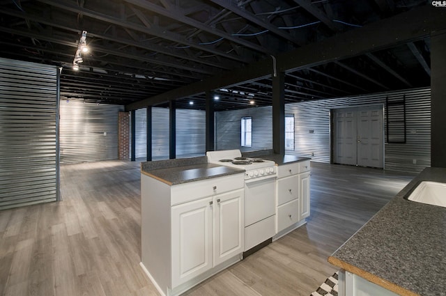 kitchen featuring light wood finished floors, electric range, and dark countertops