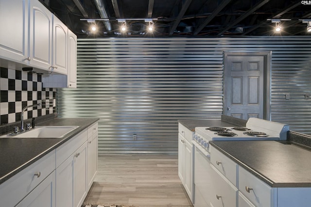 kitchen with light wood-type flooring, white cabinetry, electric range, and sink