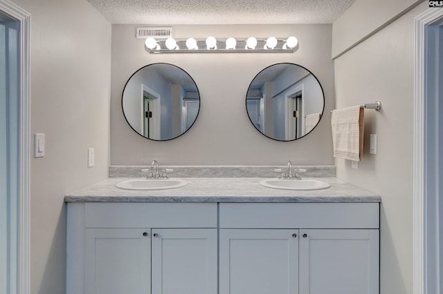 bathroom with a textured ceiling and vanity