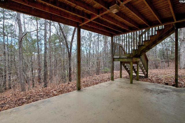 view of patio / terrace featuring stairway and a view of trees