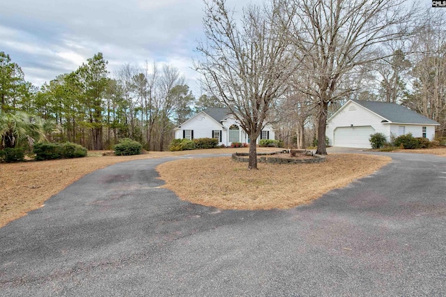 single story home with aphalt driveway and an attached garage