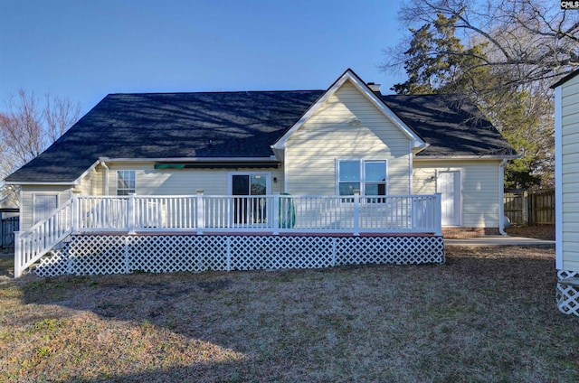 back of property featuring a wooden deck and a yard