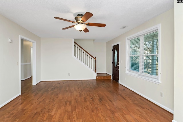 interior space with dark wood-type flooring, ceiling fan, and a textured ceiling