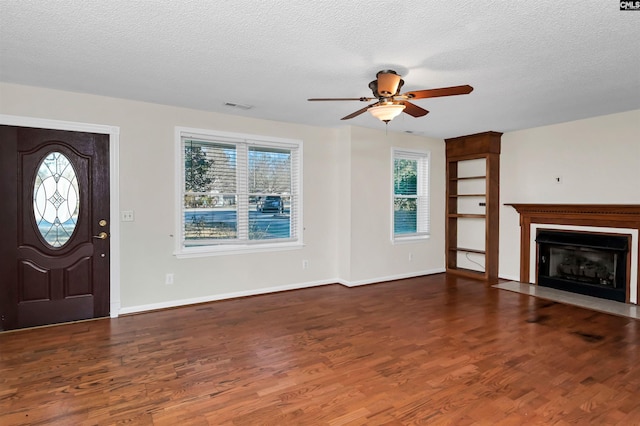 foyer featuring ceiling fan, dark hardwood / wood-style floors, a wealth of natural light, and a textured ceiling