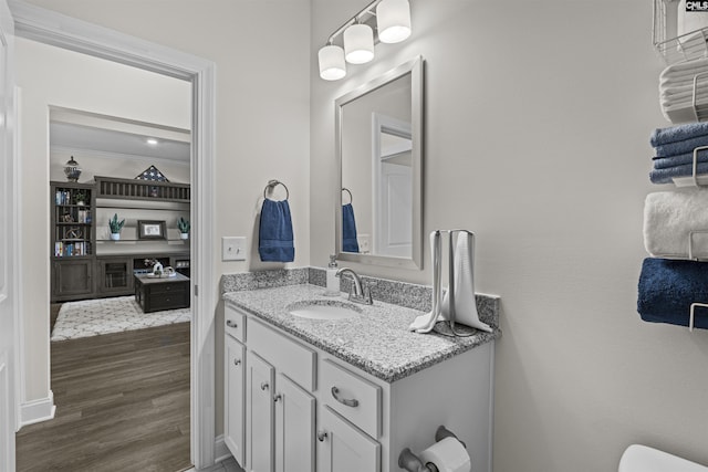 bathroom featuring crown molding, vanity, and wood finished floors