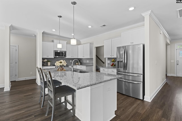 kitchen featuring dark wood-style flooring, a sink, visible vents, appliances with stainless steel finishes, and backsplash