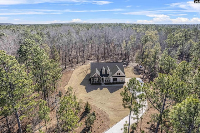 bird's eye view with a wooded view