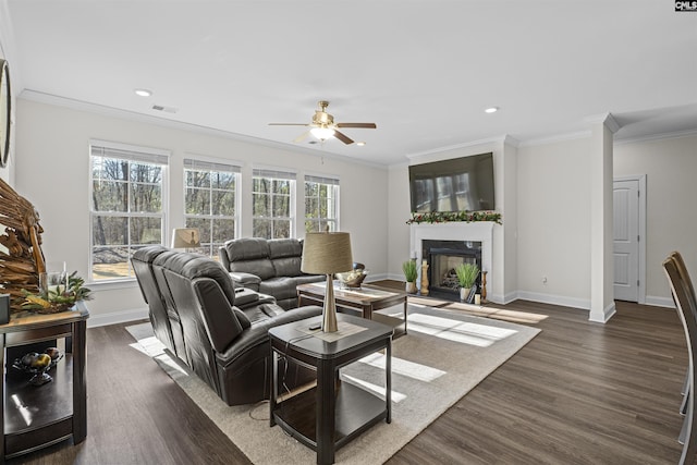 living area with a fireplace with flush hearth, dark wood-style flooring, crown molding, and plenty of natural light