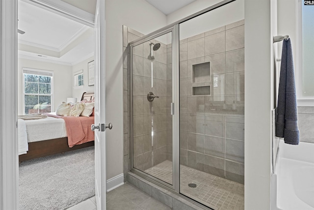 ensuite bathroom featuring crown molding, ensuite bathroom, a shower stall, baseboards, and tile patterned floors