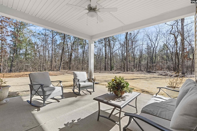 view of patio with a forest view and ceiling fan