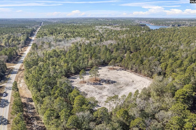 drone / aerial view featuring a forest view and a water view