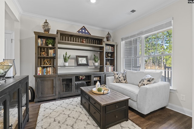 sitting room with baseboards, visible vents, dark wood-type flooring, and crown molding