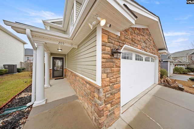 doorway to property featuring a garage and cooling unit