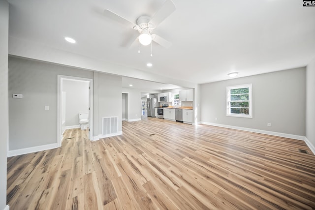 unfurnished living room with ceiling fan and light wood-type flooring