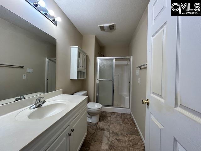 full bath with toilet, a stall shower, visible vents, and vanity