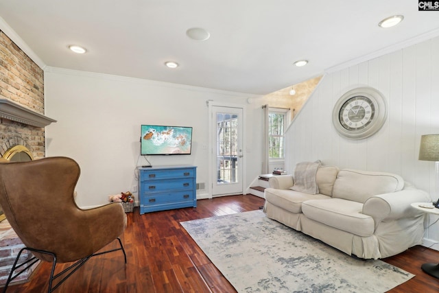 living room featuring dark wood-type flooring, ornamental molding, and a fireplace