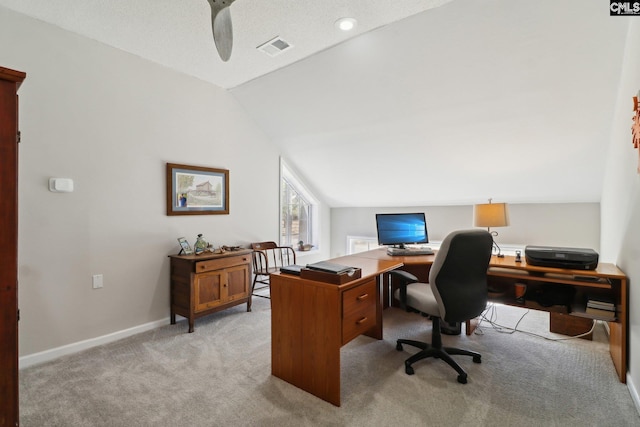 carpeted office with vaulted ceiling and a textured ceiling