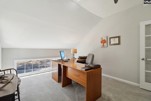 carpeted office space featuring vaulted ceiling