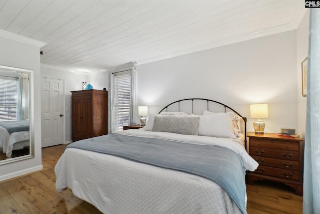 bedroom featuring wooden ceiling, crown molding, hardwood / wood-style floors, and multiple windows