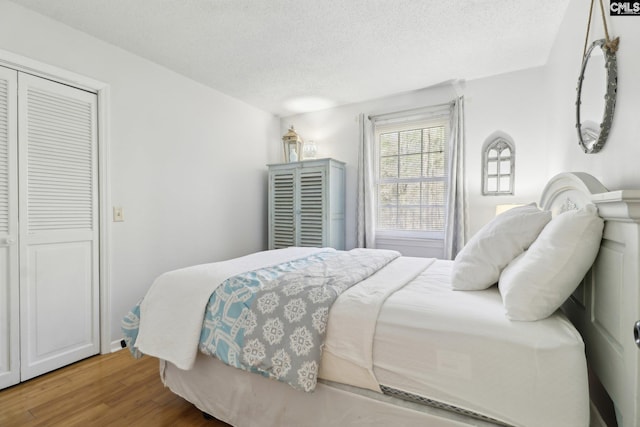 bedroom featuring a textured ceiling, a closet, and hardwood / wood-style floors