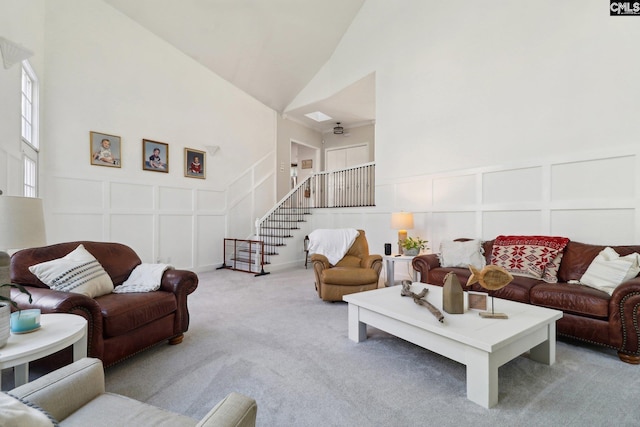 carpeted living room with high vaulted ceiling