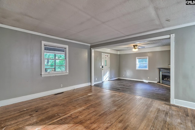 empty room with ceiling fan, dark wood-type flooring, a textured ceiling, and ornamental molding