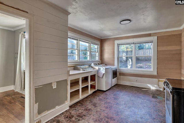 laundry area with wood walls, washing machine and clothes dryer, and ornamental molding