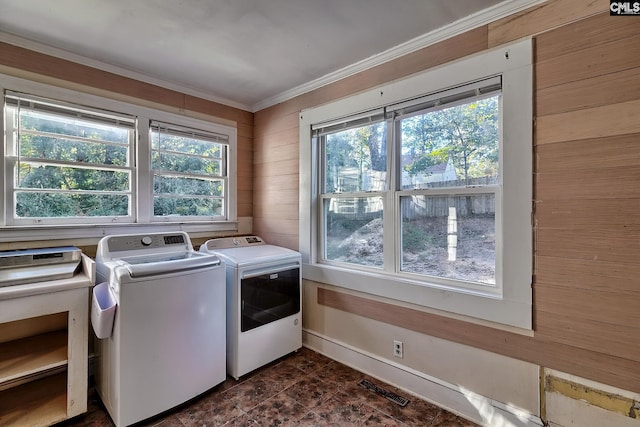 laundry area with washing machine and dryer and wood walls