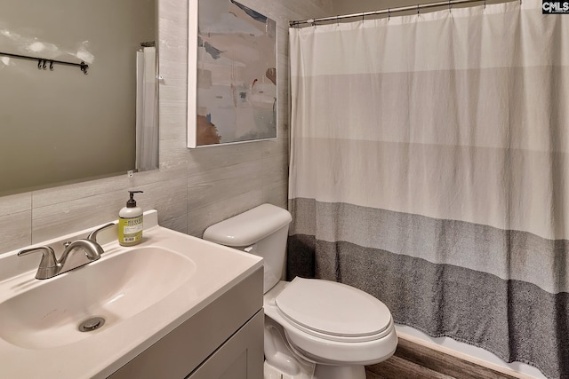 bathroom with toilet, vanity, tile walls, walk in shower, and tasteful backsplash