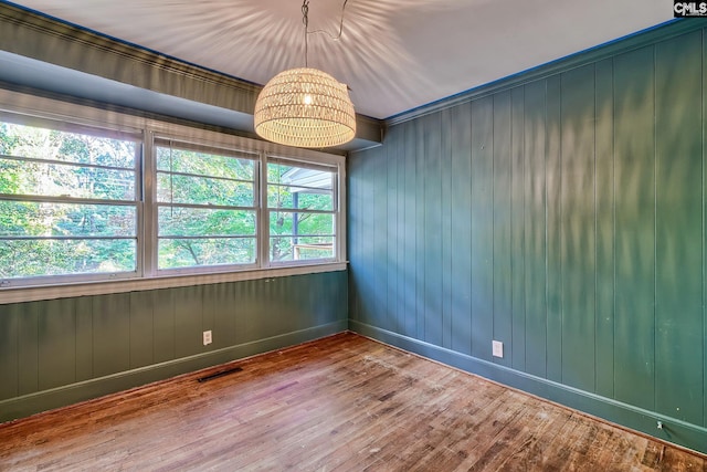 spare room with hardwood / wood-style floors and wood walls