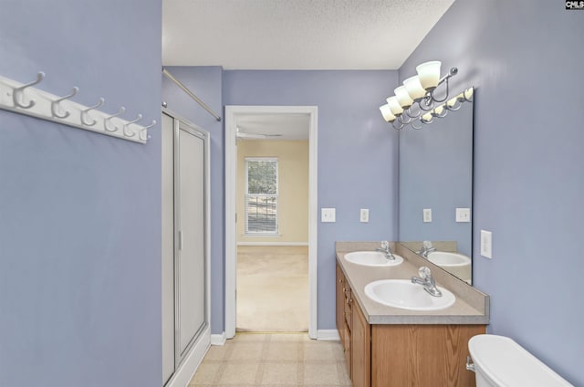 bathroom featuring a textured ceiling, toilet, and vanity