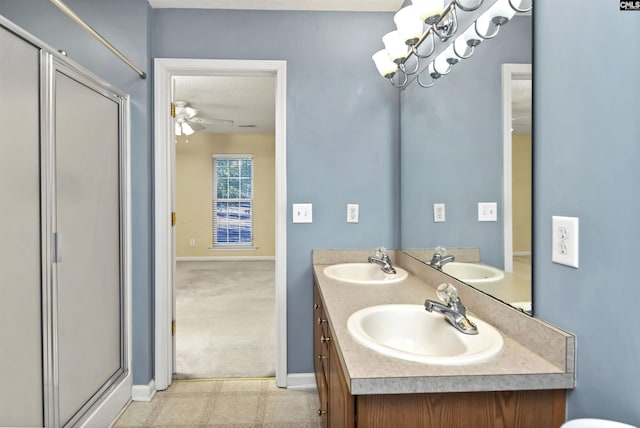 bathroom featuring a textured ceiling, ceiling fan, a shower with door, and vanity