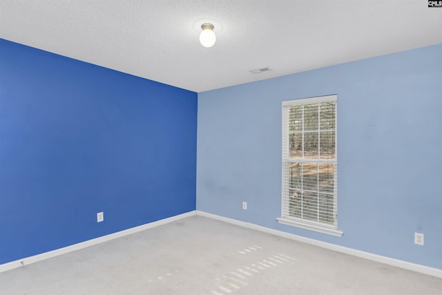 unfurnished room with carpet floors and a textured ceiling