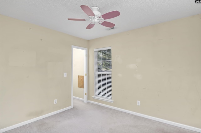 unfurnished room featuring light carpet, ceiling fan, and a textured ceiling