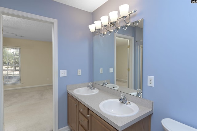 bathroom featuring a textured ceiling, toilet, and vanity