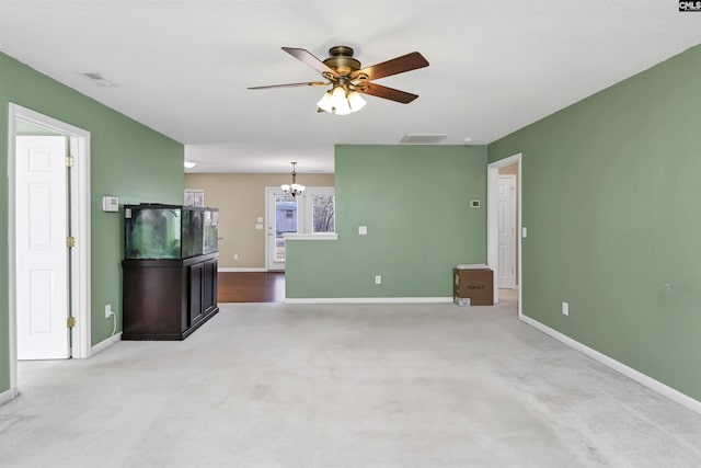 unfurnished living room with light carpet and ceiling fan with notable chandelier