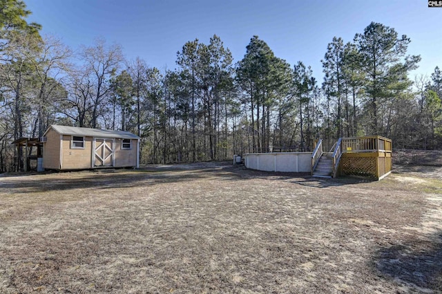 view of yard featuring a storage shed and a swimming pool side deck