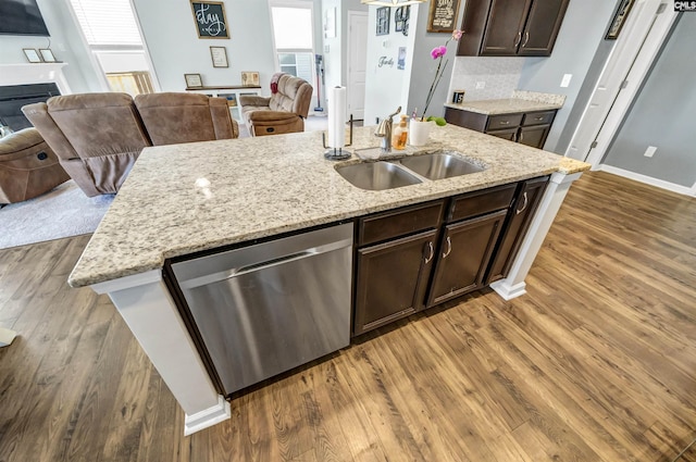 kitchen featuring dark brown cabinetry, dark hardwood / wood-style flooring, sink, backsplash, and stainless steel dishwasher