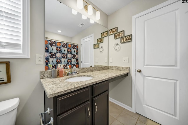 bathroom featuring toilet, vanity, and tile patterned flooring