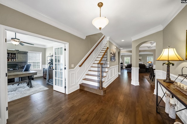 foyer entrance with dark wood-type flooring, ceiling fan, and crown molding